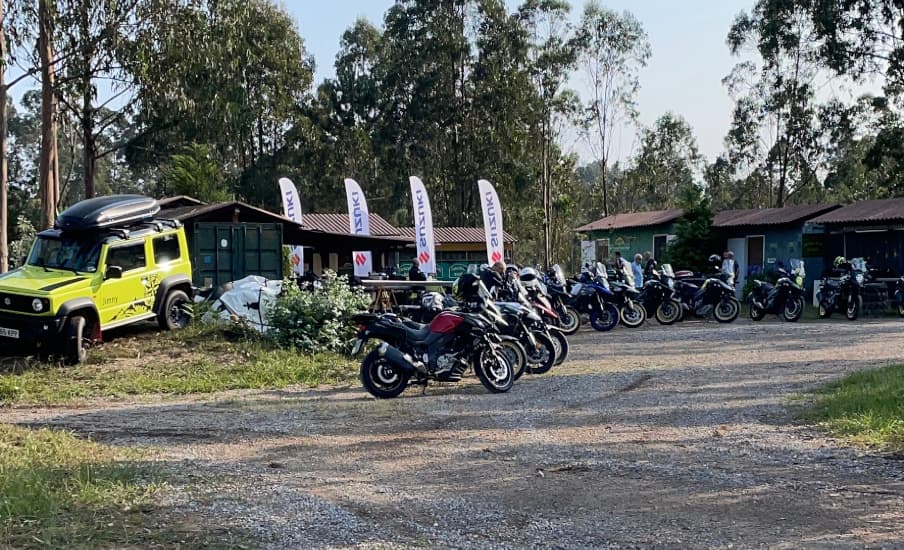 Explanada de grava del recinto con las naves al fondo y una fila de motos aparcadas durante un evento.